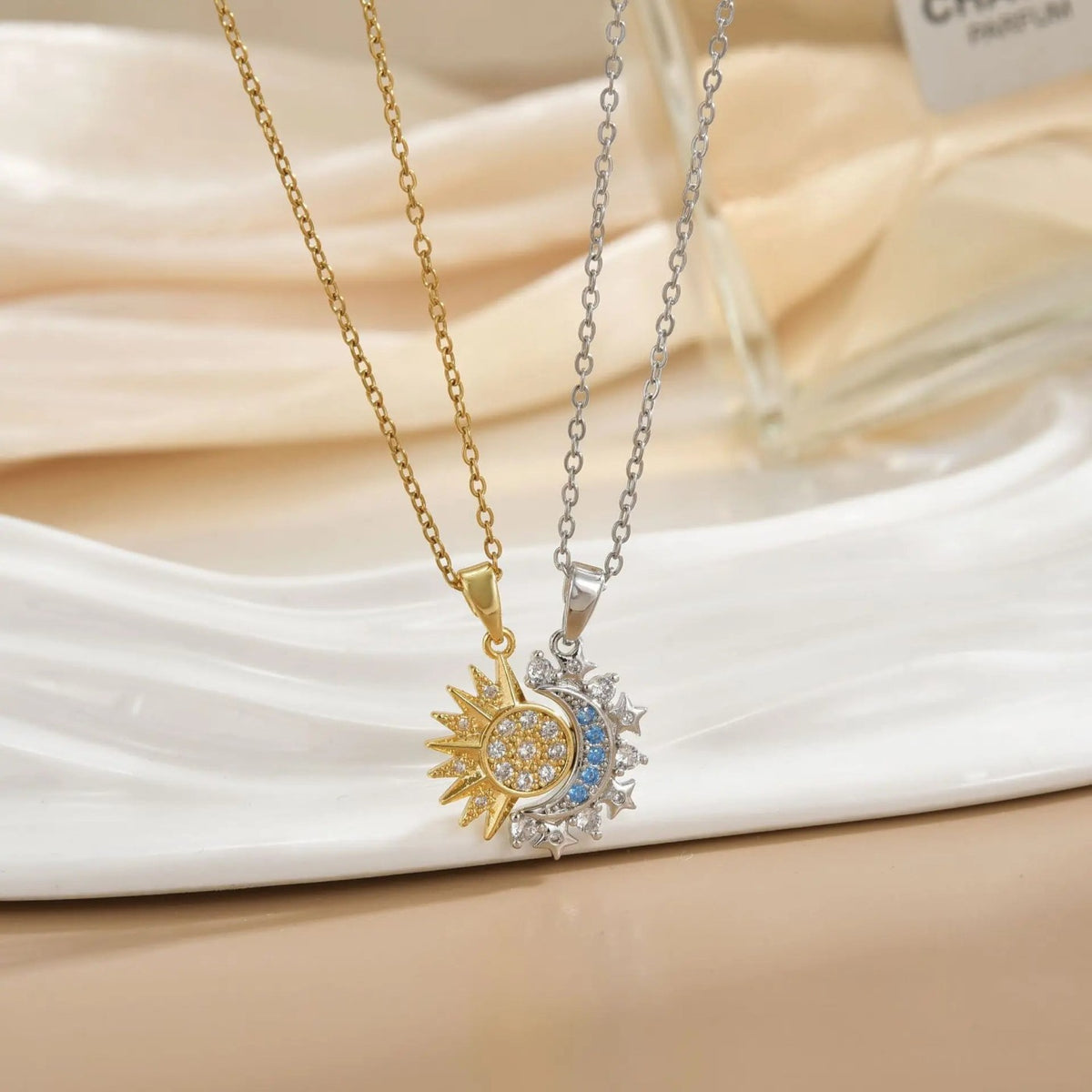 Collares sol y luna conectados sobre seda — foto real del producto